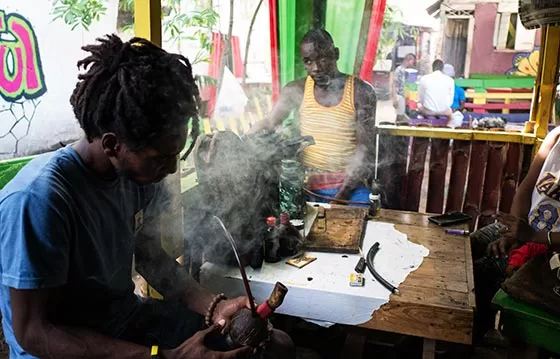 Young men smoking marijuana in what looks like Jamaica.