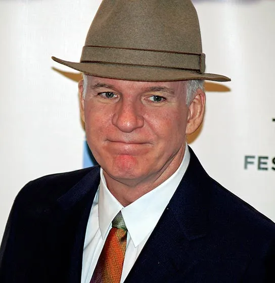 Steve Martin in a suit, wearing a hat